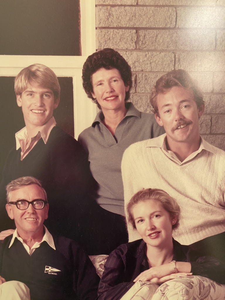 Family portrait from the early 1980s, five family members posed in front of a brick wall